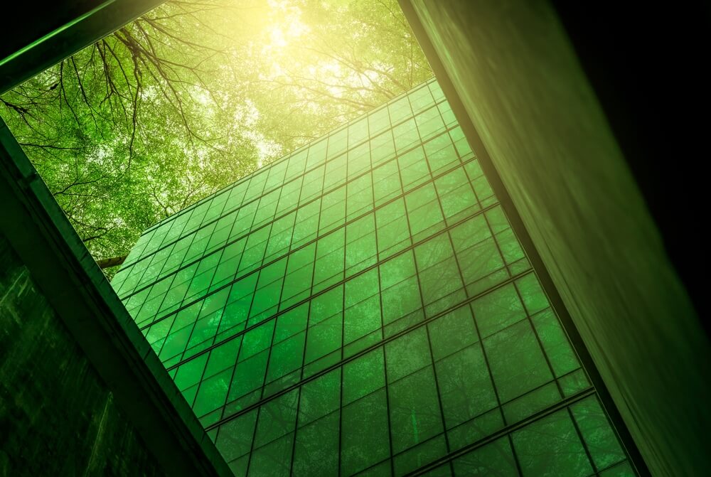 glass building with green trees above