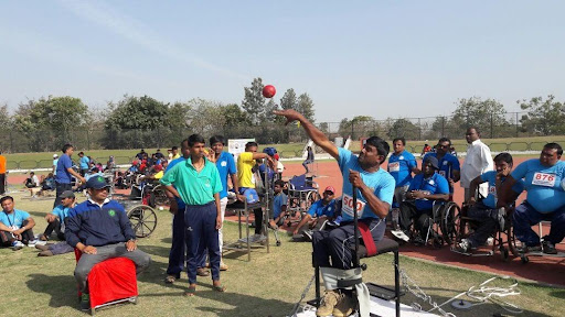 Ravi throwing shotput surrounded by onlookers at the games